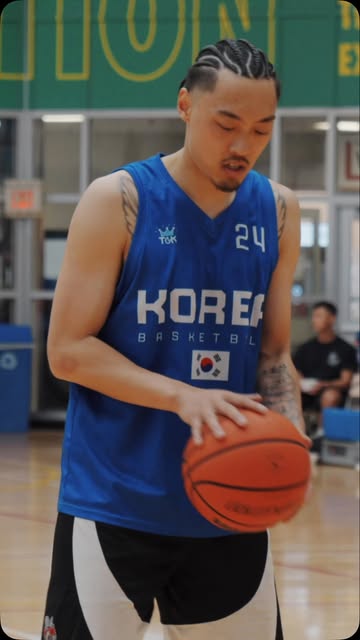 A player in a blue Korea Basketball jersey number 24 palming a basketball on court.