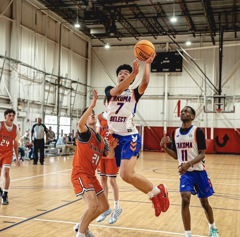 Myles Kim, number 7 in a Takoma Select jersey, rising for a layup past a defender.