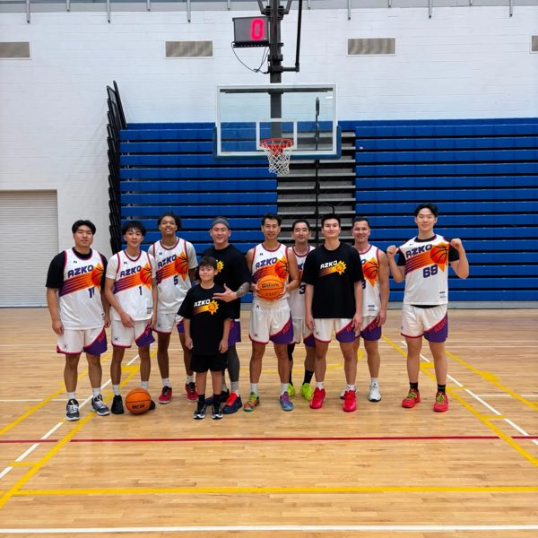 The Arizona squad in white and black AZKO jerseys, lined up under the hoop with a young supporter in front.