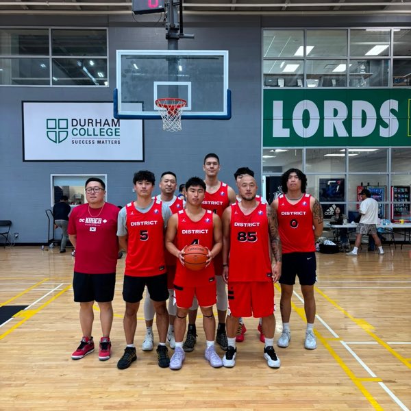 The District squad in red jerseys with their coach in a DC Korea Basketball shirt.