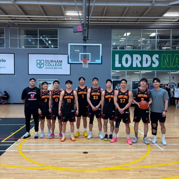 The Maryland squad in black and orange jerseys, lined up on the Durham College court.