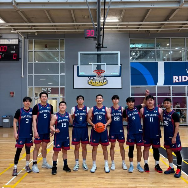 The New Jersey squad in navy jerseys with Korean flag patches, lined up beneath the backboard.