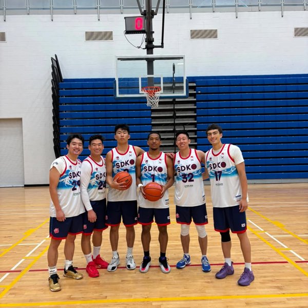 The San Diego squad in white and navy SDK jerseys, gathered at the baseline with two balls.